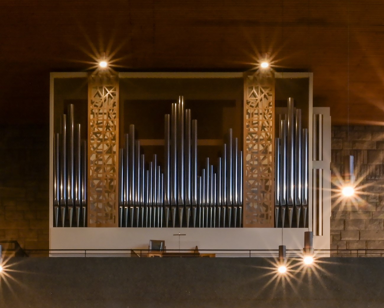 Orgel in einem weißen, rechteckigen Gehäuse, vorne offen mit gitterartigem Schauprospekt an 2 Stellen