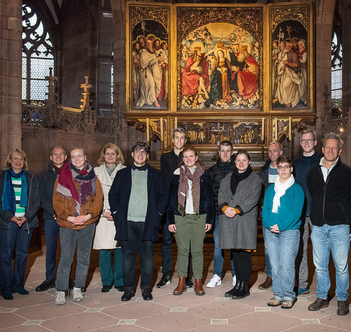 Gruppe von Frauen und Männern vor dem Altar im Freiburger Münster