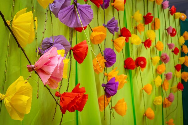 bunte Papierblumen auf grüner Wand