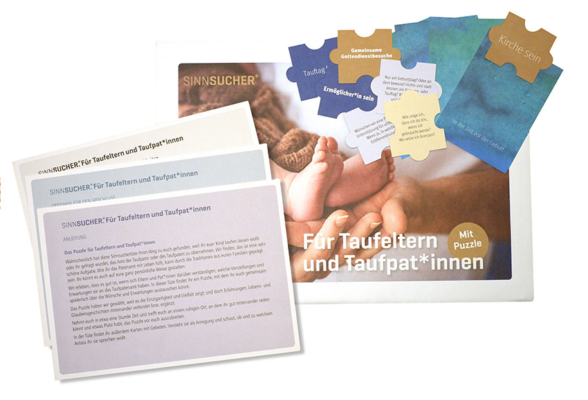 Textkarten, Puzzelteile , ein Umschlag mit einem Bild mit Babyfüsschen in einer Erwachsenenhand