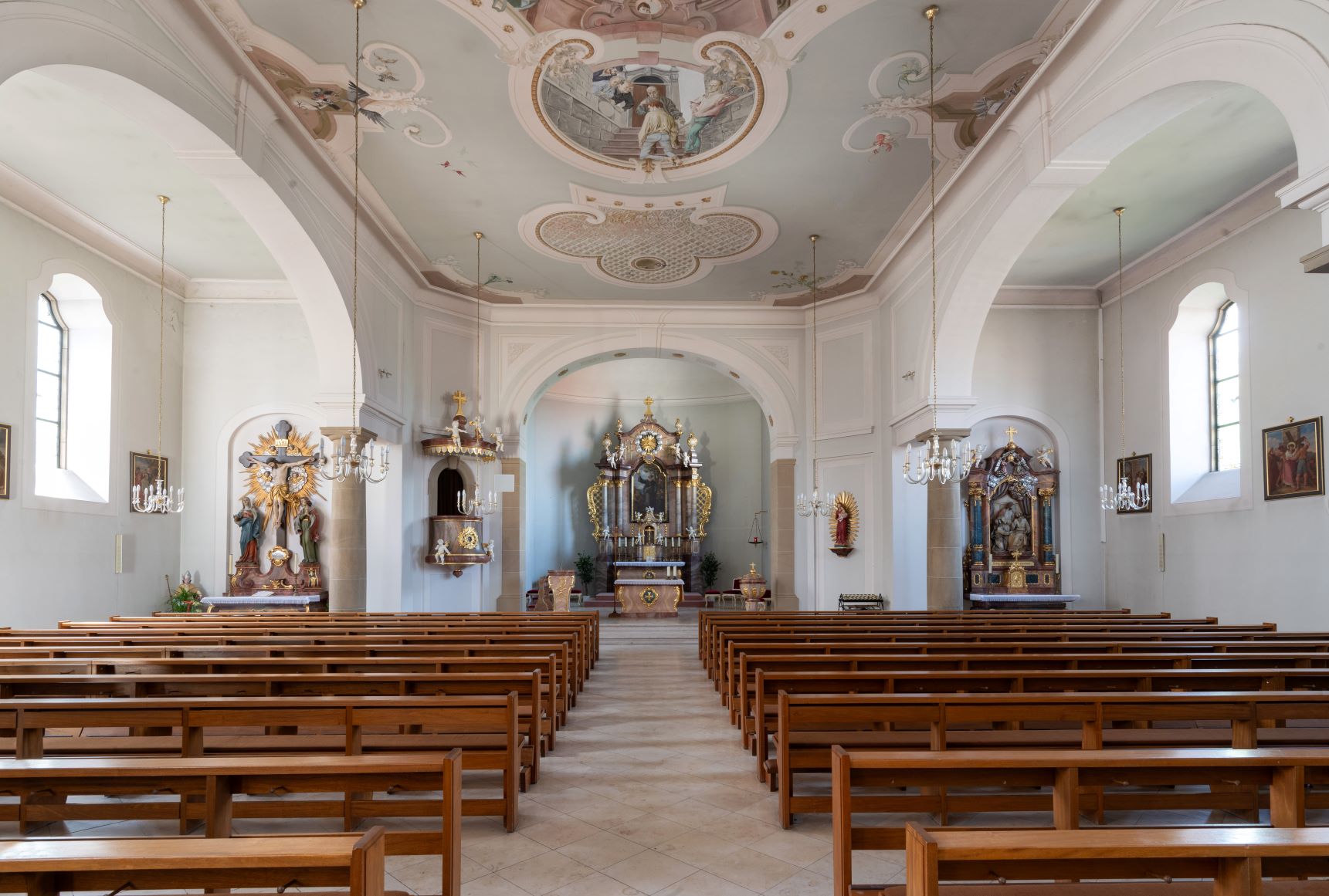Blick in eine helle, leicht barocke Kirche Richtung Altar