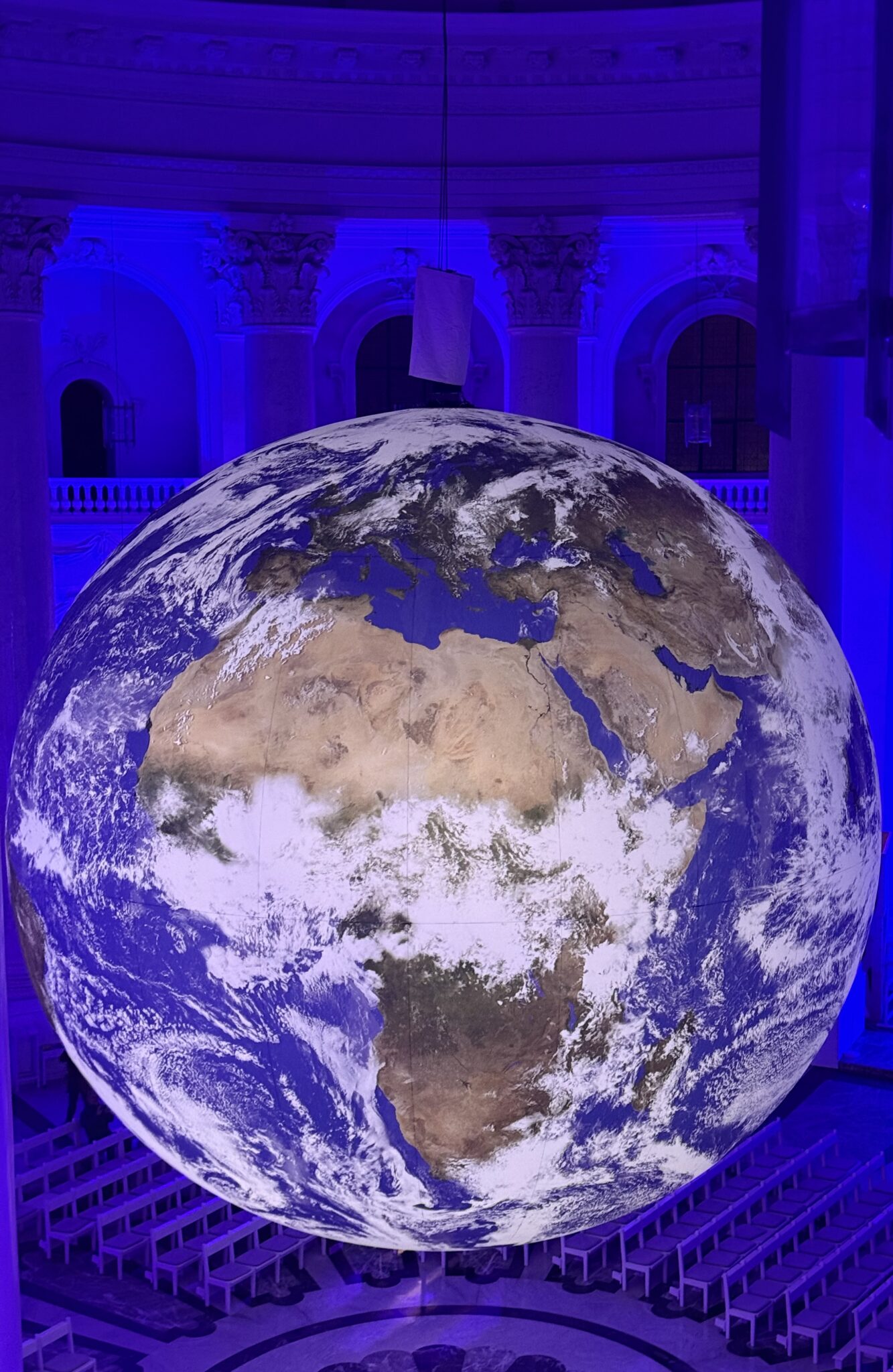 Erdkugel in einer großen Kuppelkirche im blauen Licht